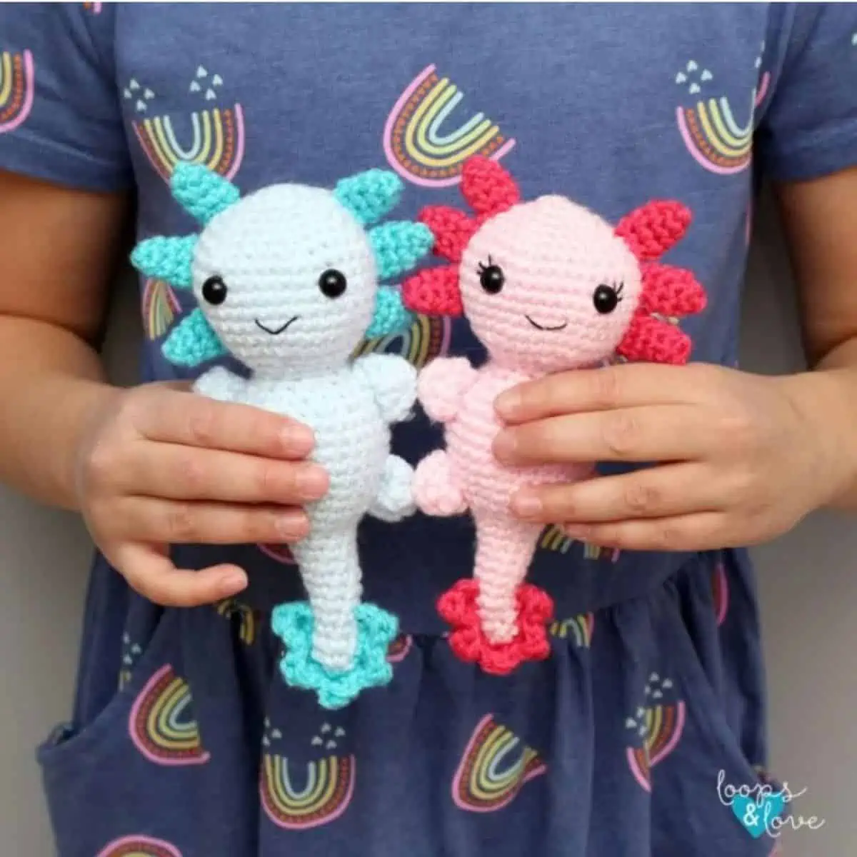 two axolotl crochet toys being held