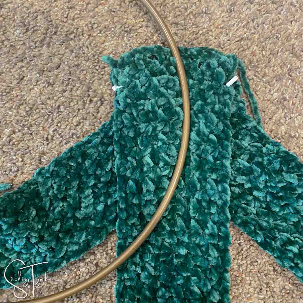 3 strips of green crochet fabric under a metal hoop