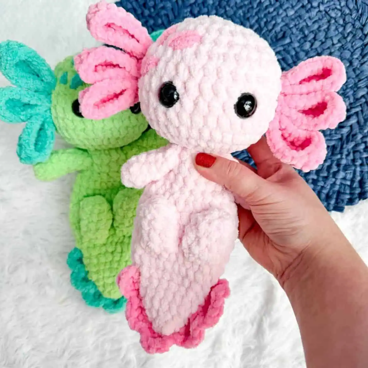 hand holding a pink axolotl plushie