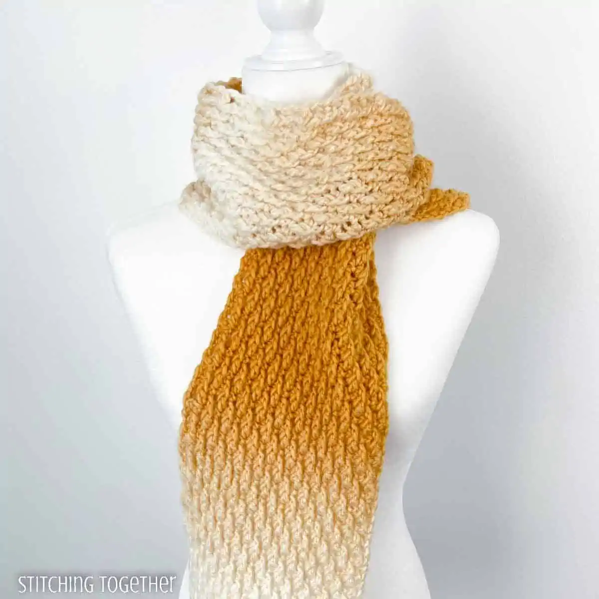 yellow and white textures scarf around the neck of a mannequin