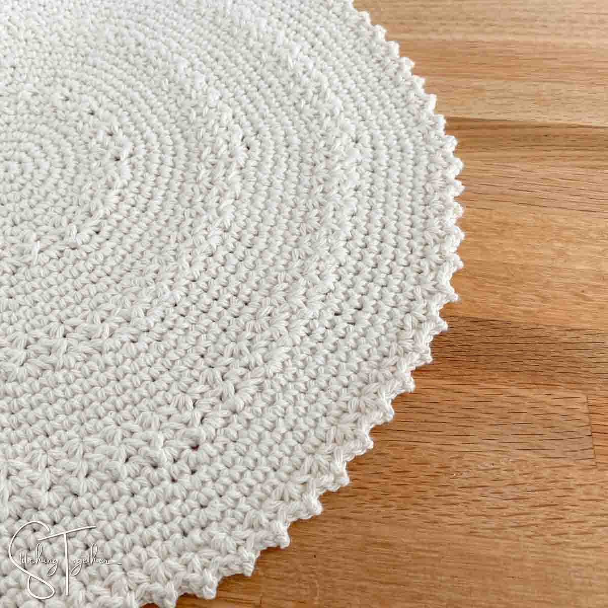 partial view of a crochet round placemat laying flat