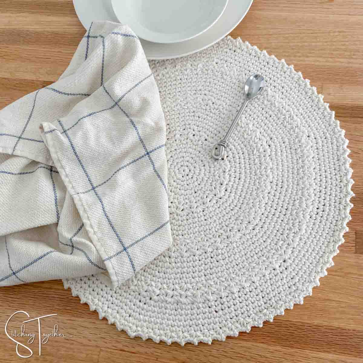 placemat, small spoon, white bowl and a kitchen towel