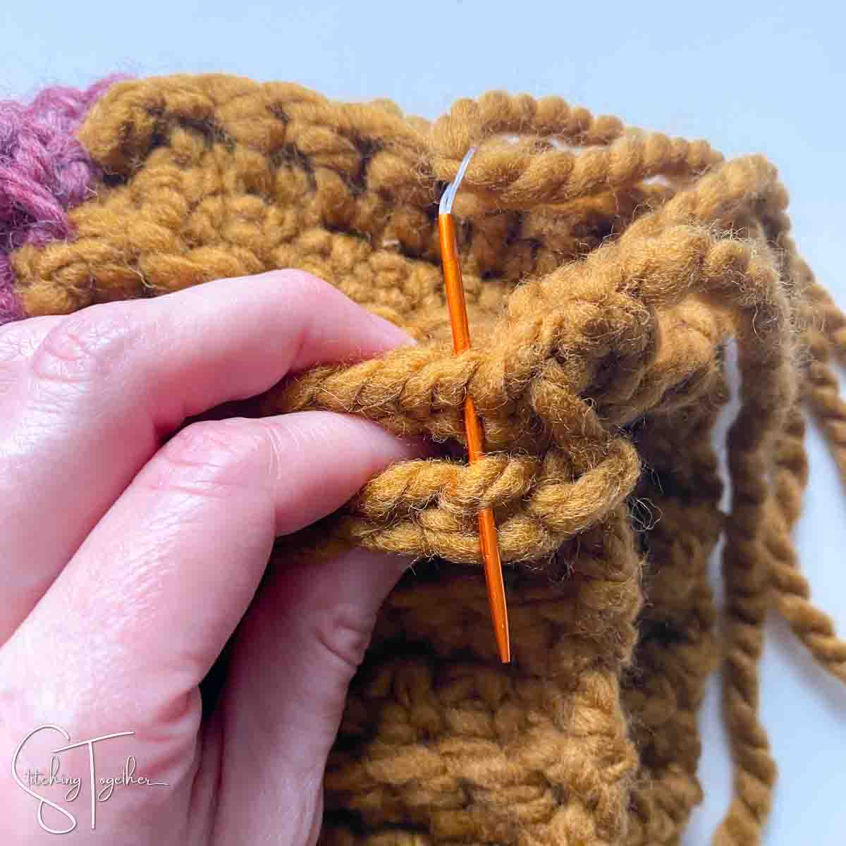 tapestry needle being woven through crochet fabric