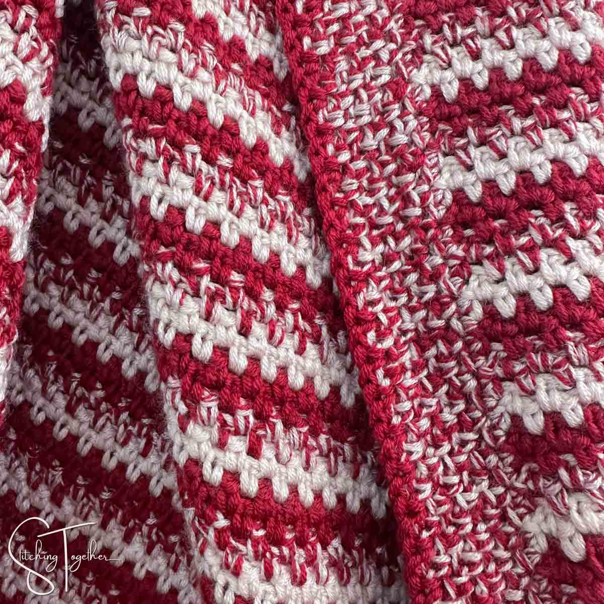 close up of the crochet moss stitch done in red, pink, and marled