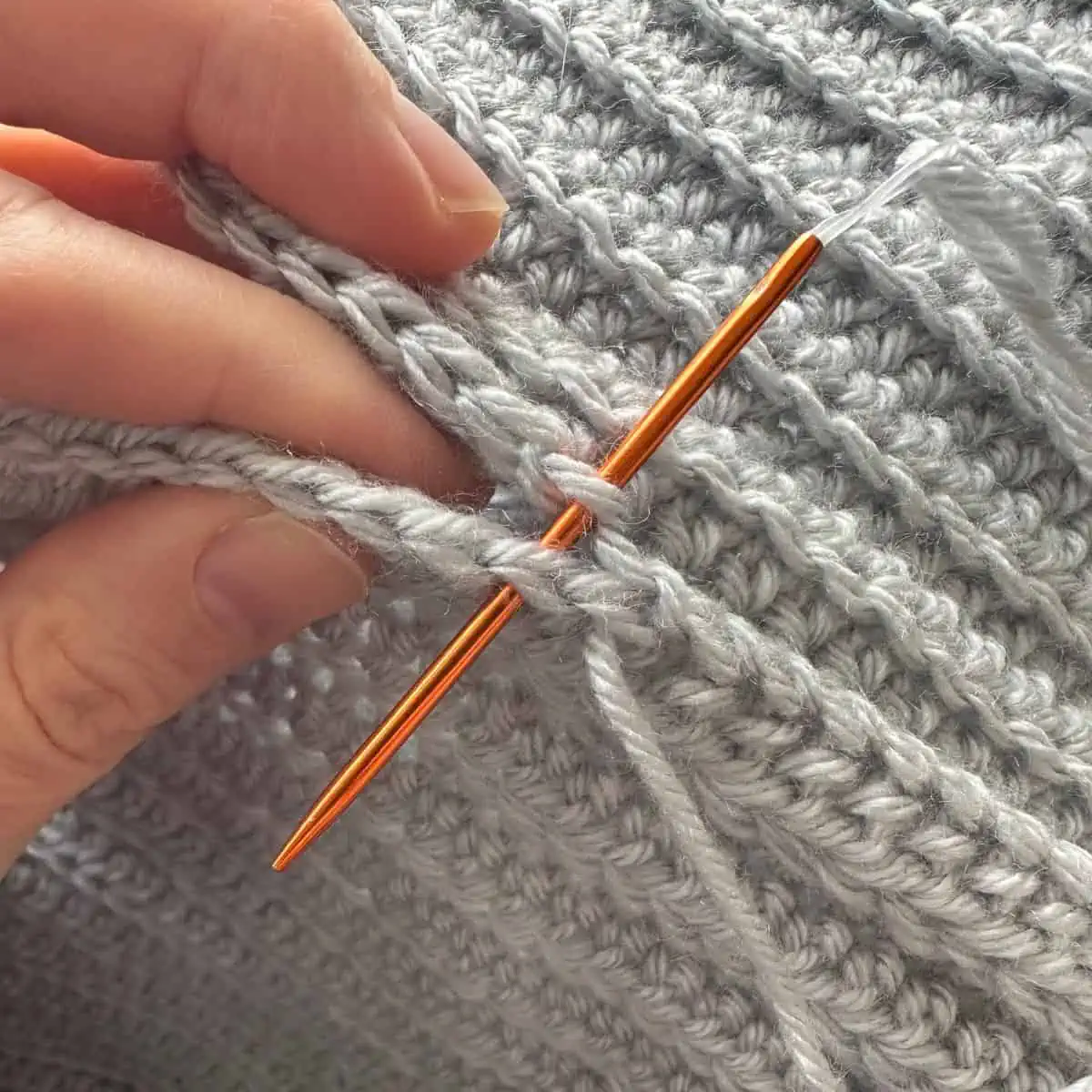 tapestry needle working through crochet stitches