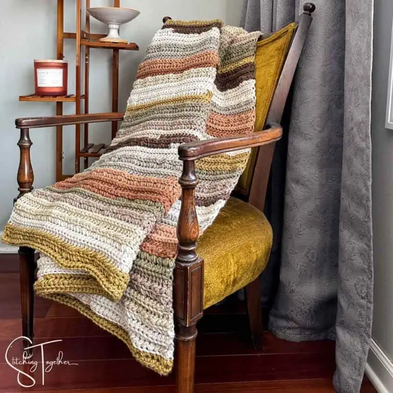 chunky crochet blanket draped on a chair