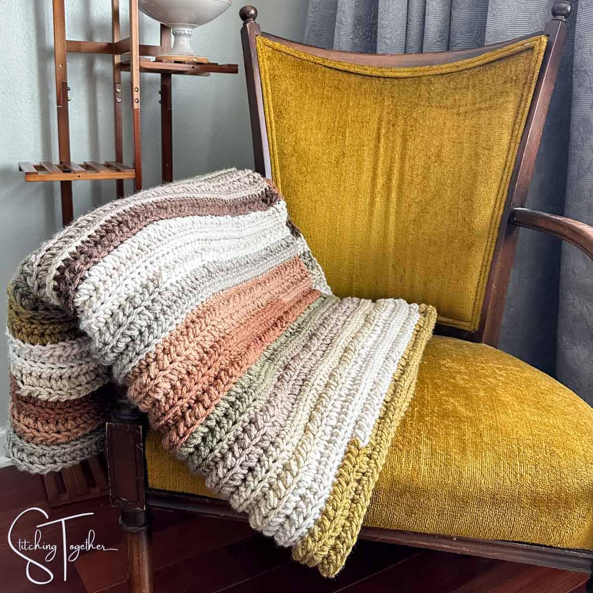 colorful chunky crochet throw draped on a chair