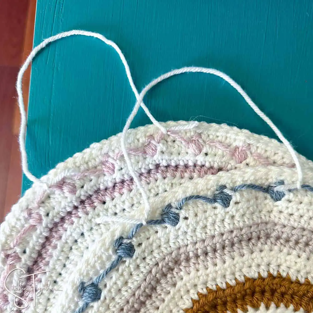 back of two crochet rainbows showing where to attach the yarn to hang them