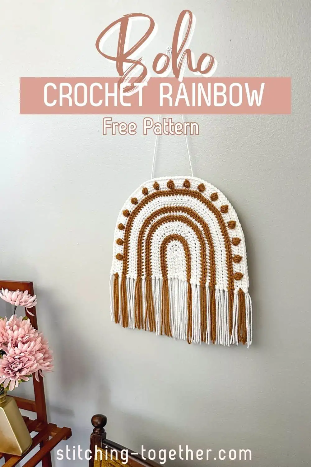 modern crochet rainbow hanging on a wall near home decor with text overlay reading "boho crochet rainbow free pattern"