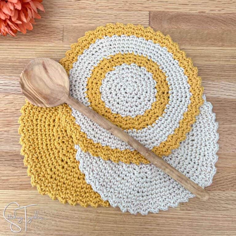 3 circle crochet dishcloths with a wooden spoon laying on top of them