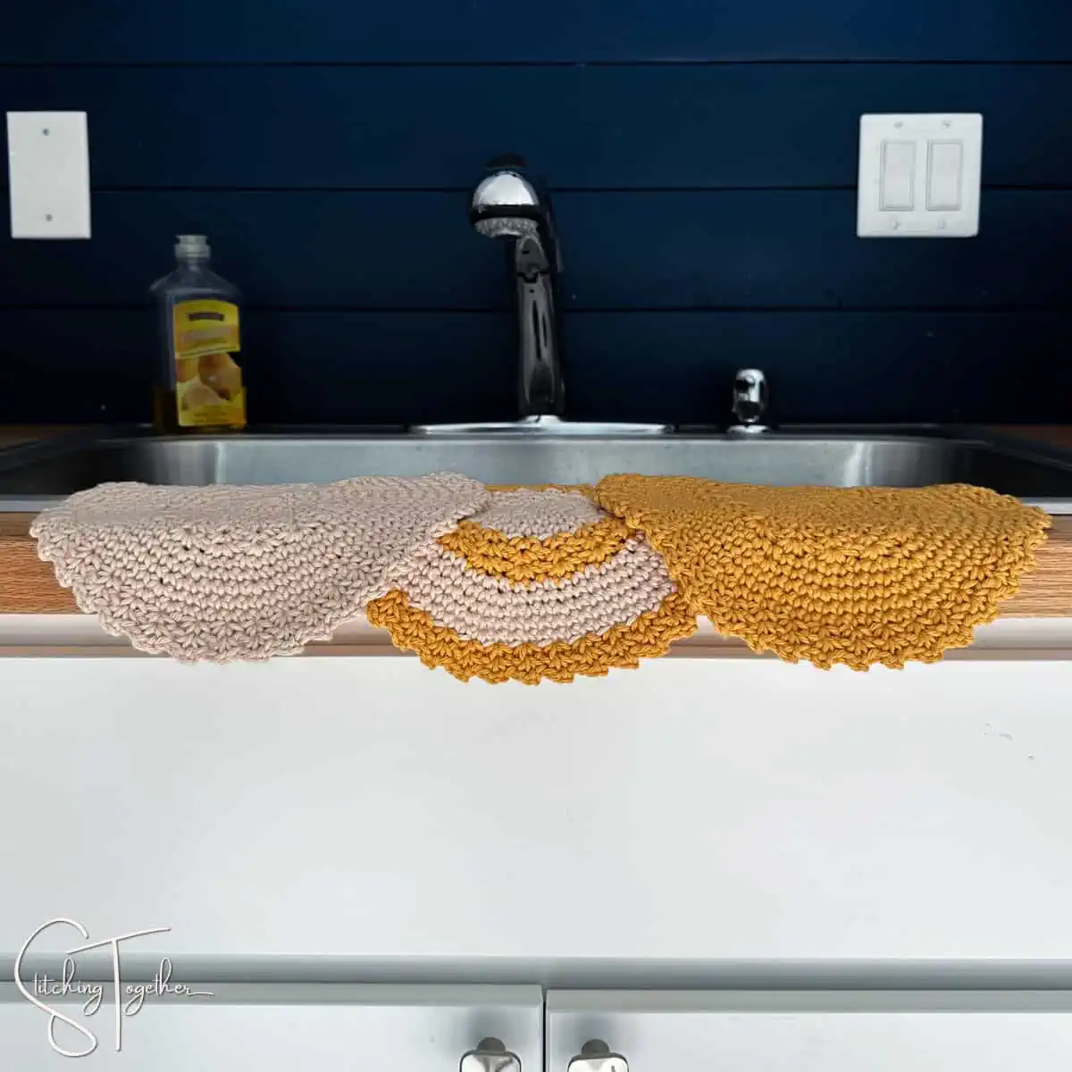 3 crochet round dishcloths draped on the side of a sink