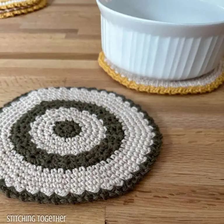 two round crochet trivets one with a dish sitting on it