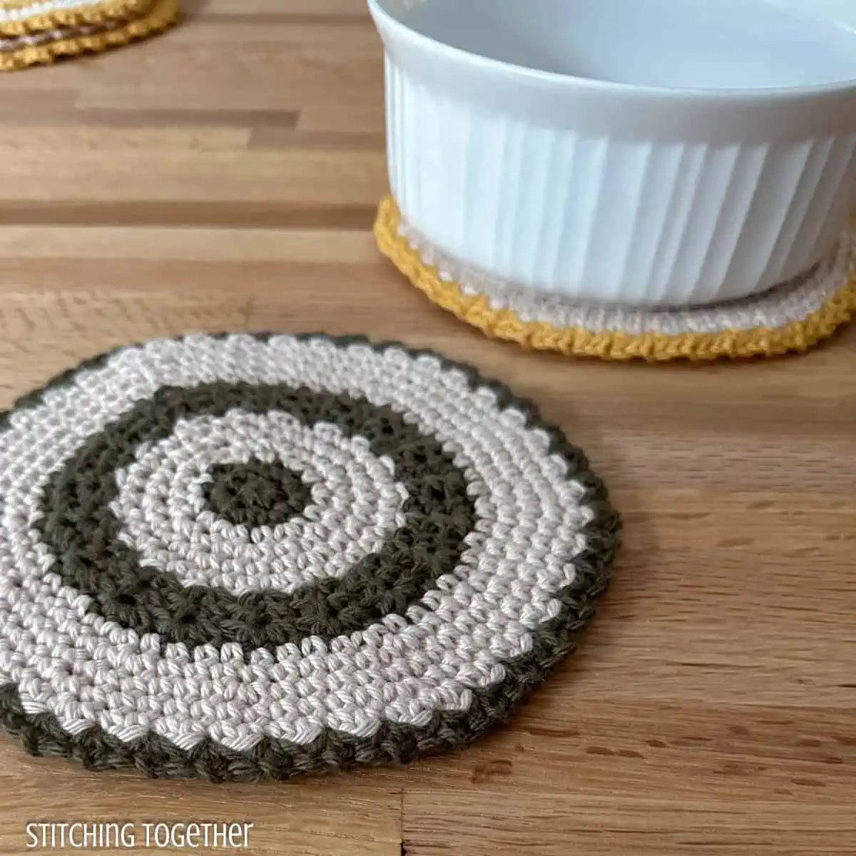 two round crochet trivets one with a dish sitting on it