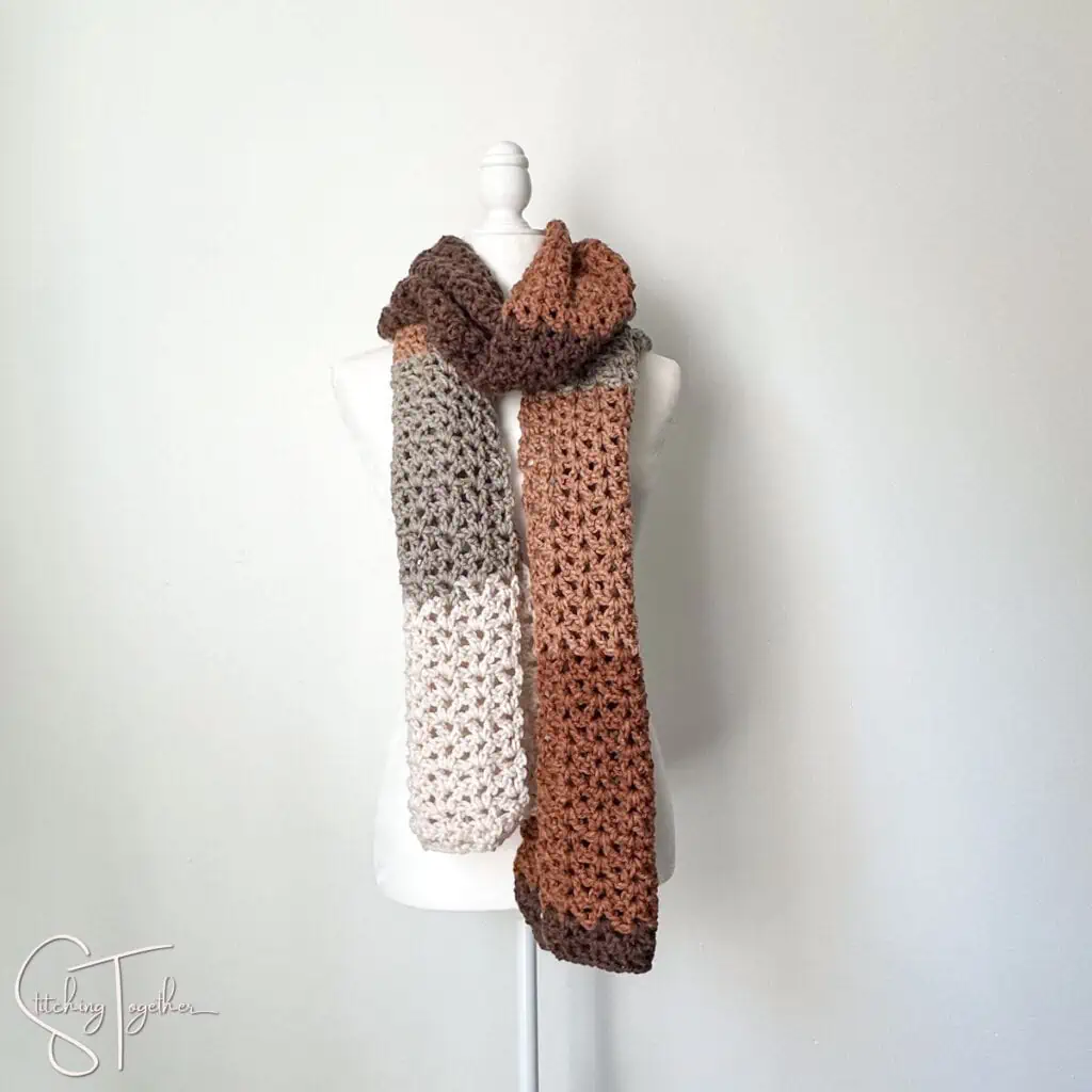 multicolored crochet scarf draped on a mannequin