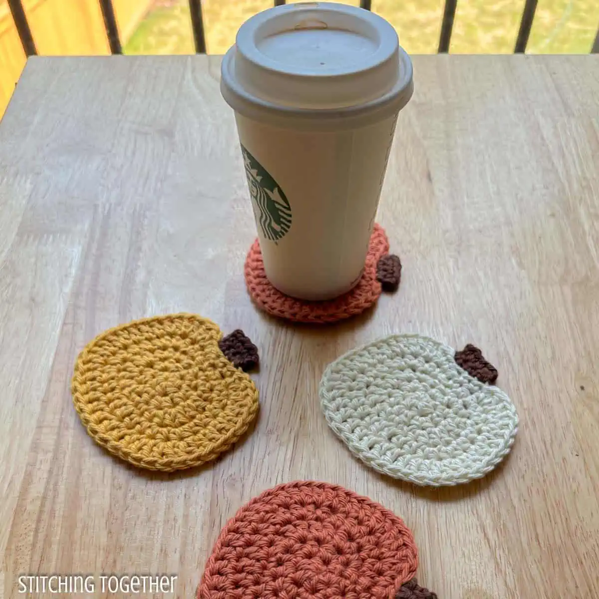 close up of crochet pumpkin with a disposable cup sitting on one