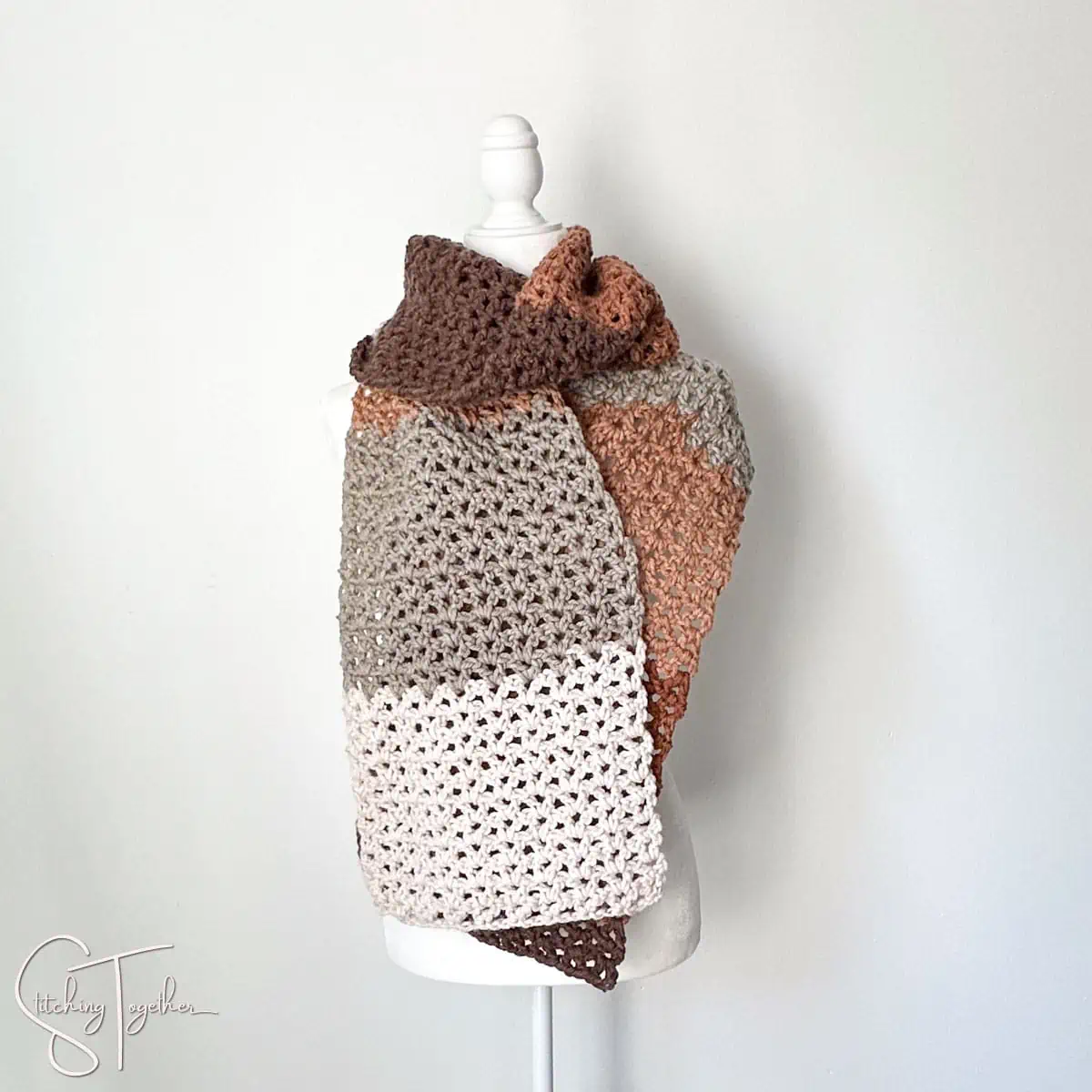 wide crochet scarf wrapped around a mannequin