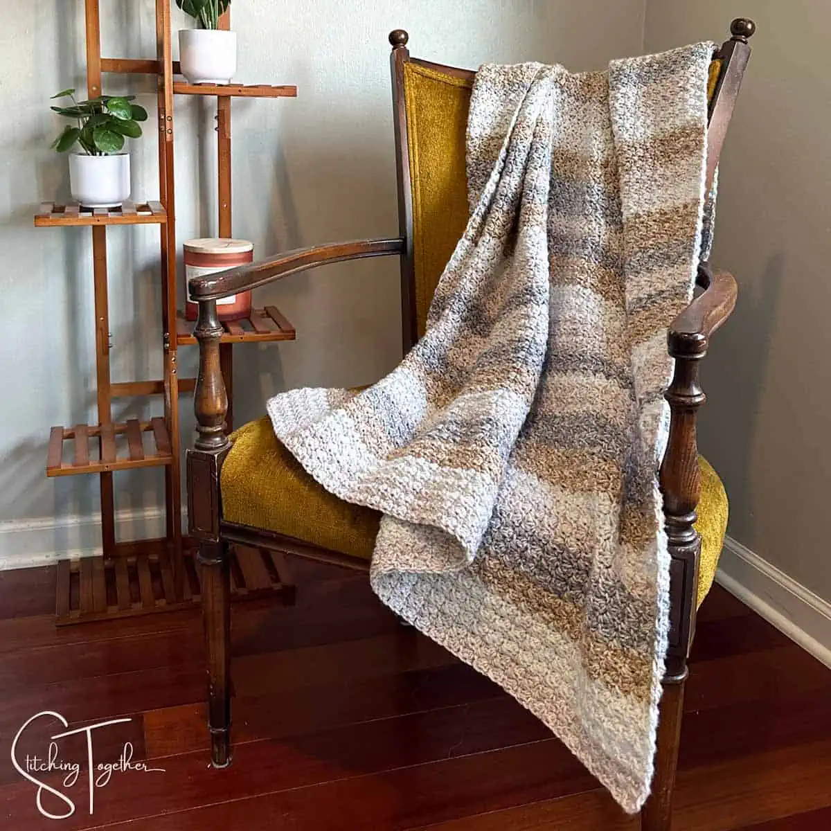 striped crochet suzette stitch blanket draped on the back of a yellow chair