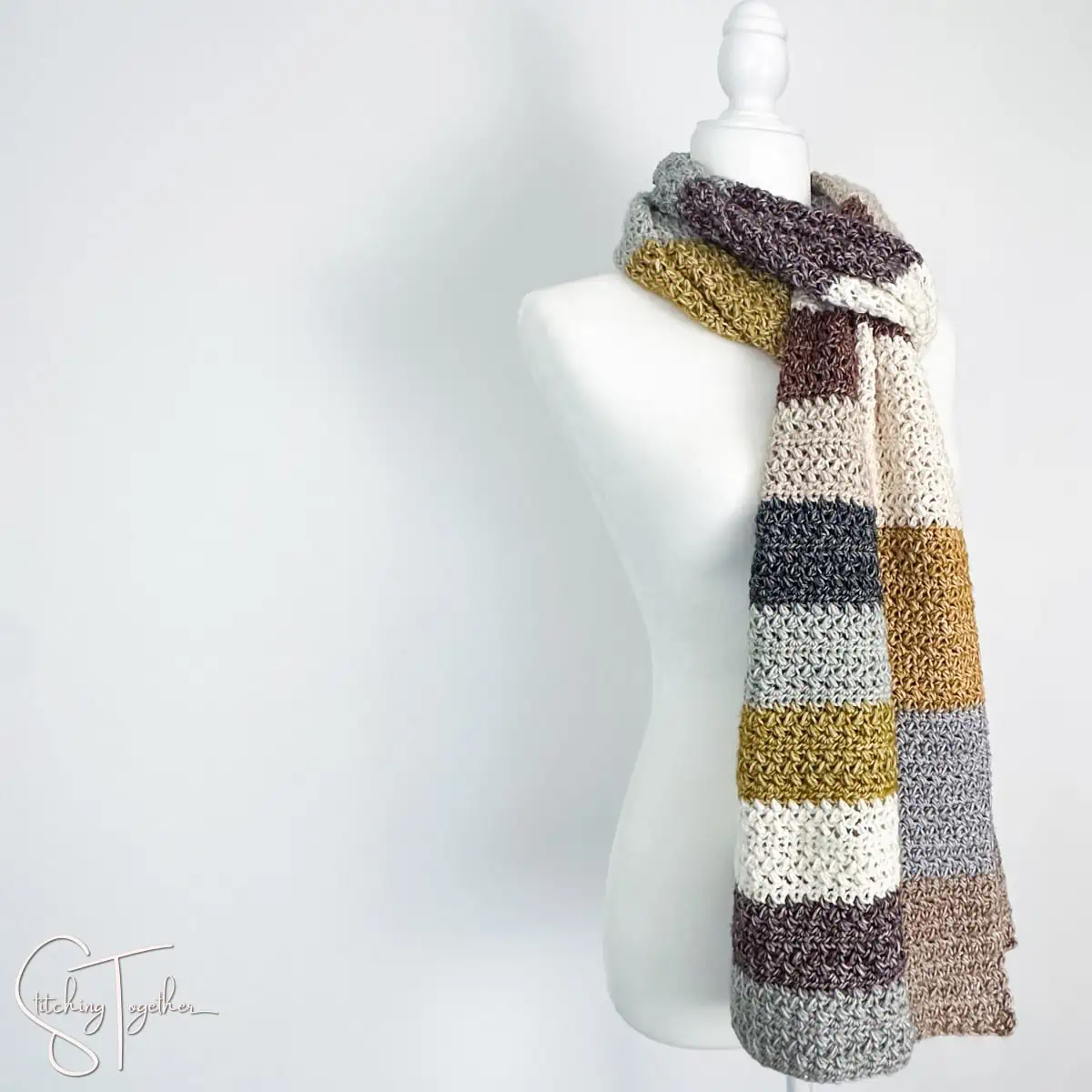long, colorful striped crochet scarf on a mannequin