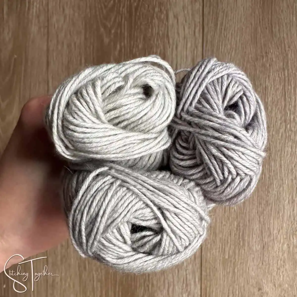 three slightly differently colored yarn being held