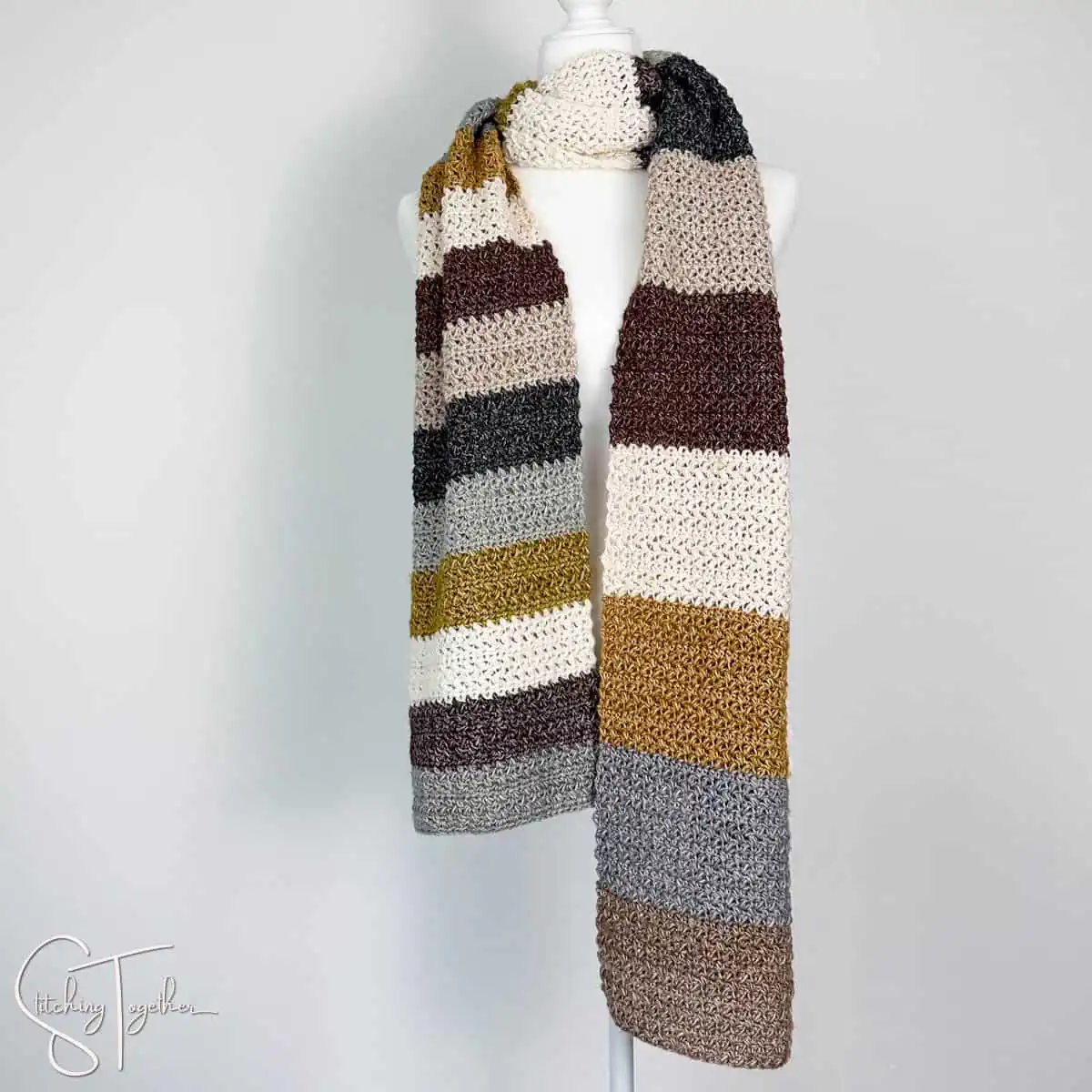 long, neutral striped crochet scarf on a mannequin