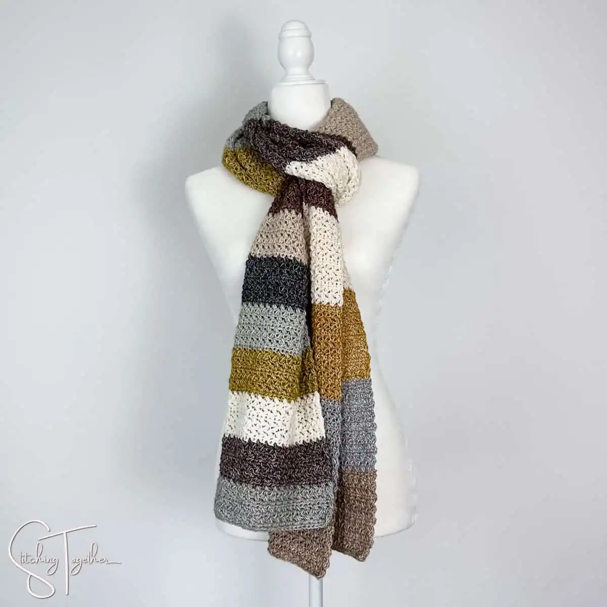 crochet scarf with stripes wrapped around the neck of a headless mannequin