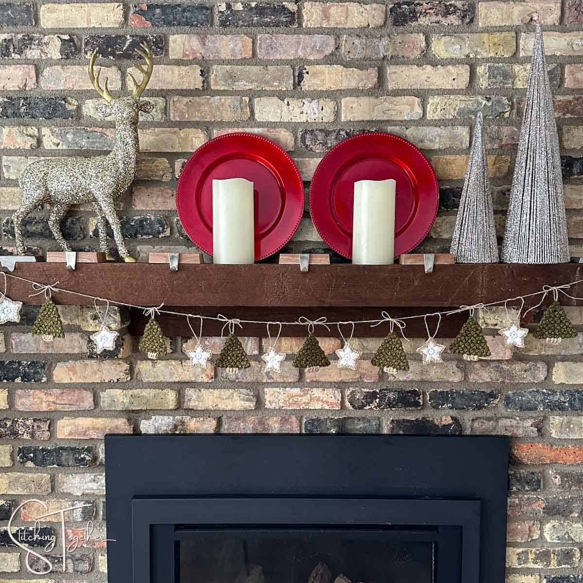 a crochet tree garland with stars hanging on a decorated mantle