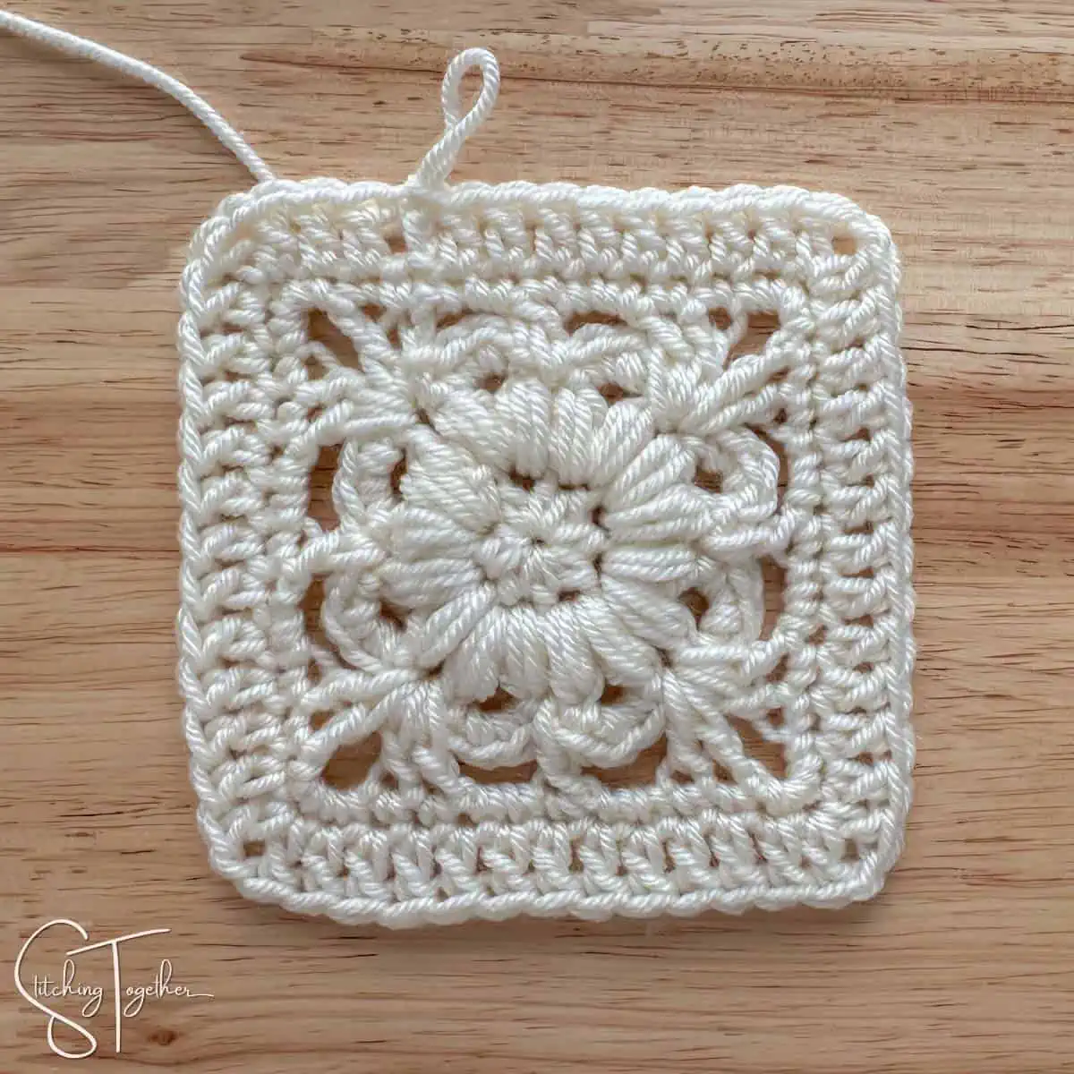 crochet flower square just finished with the yarn still attached