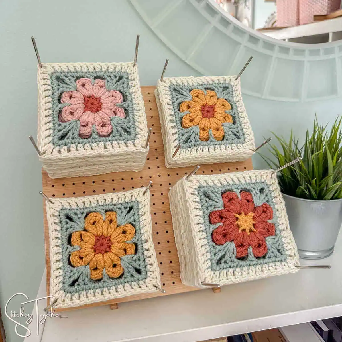 colorful crochet squares on a blocking board