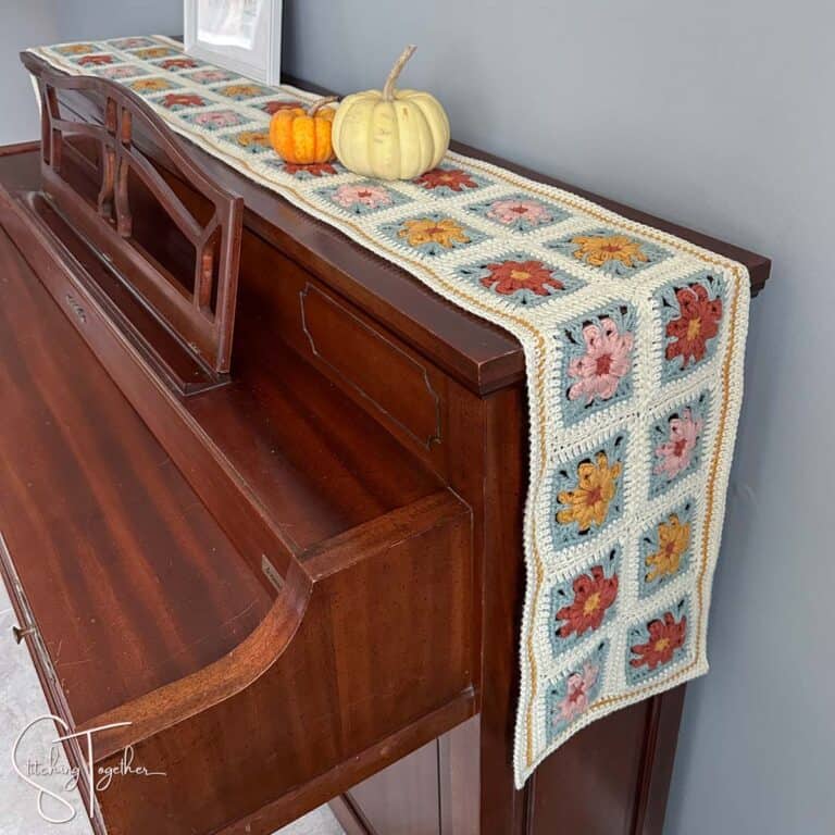 beautiful crochet granny square table runner on the back of a piano