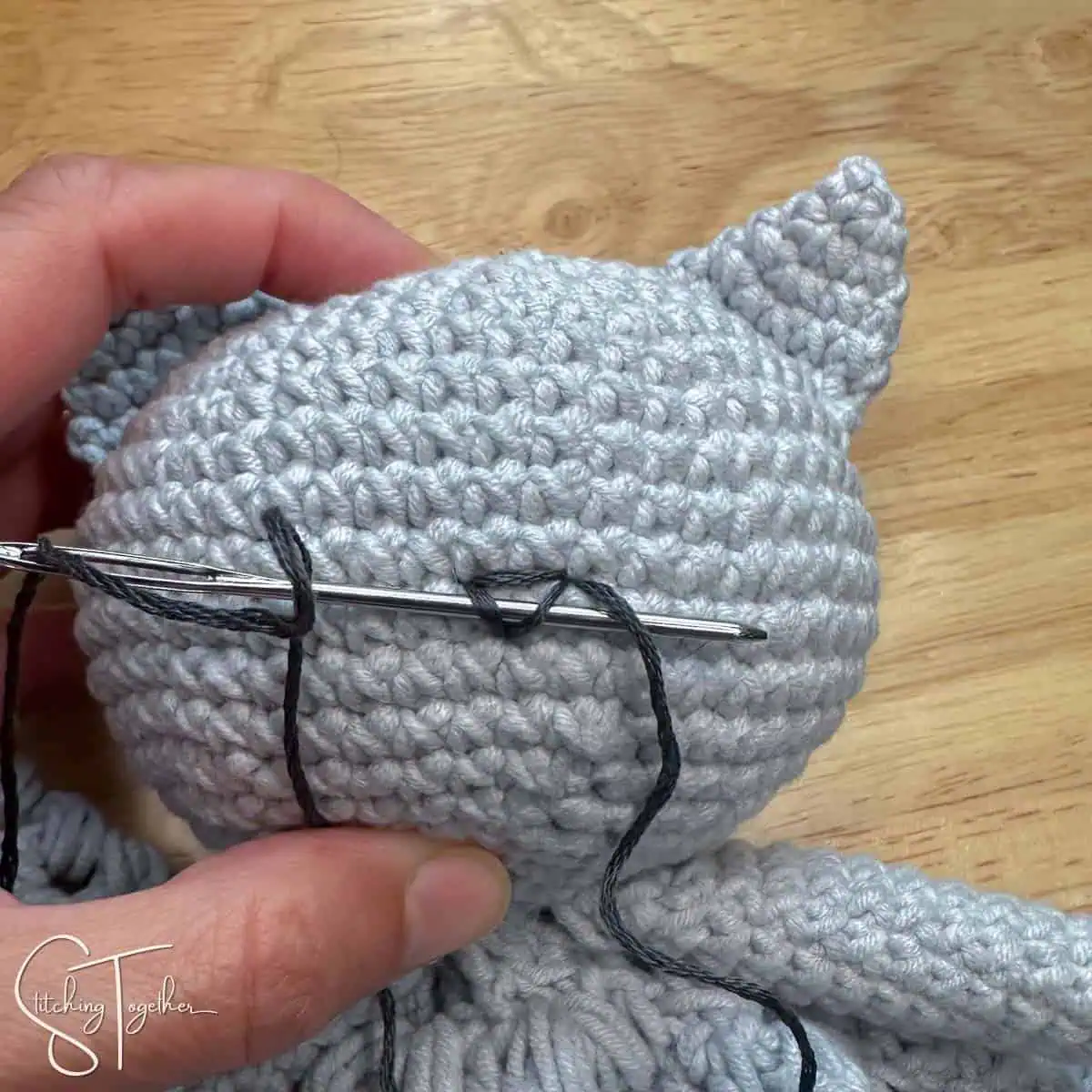 close up adding a nose to a amigurumi cat