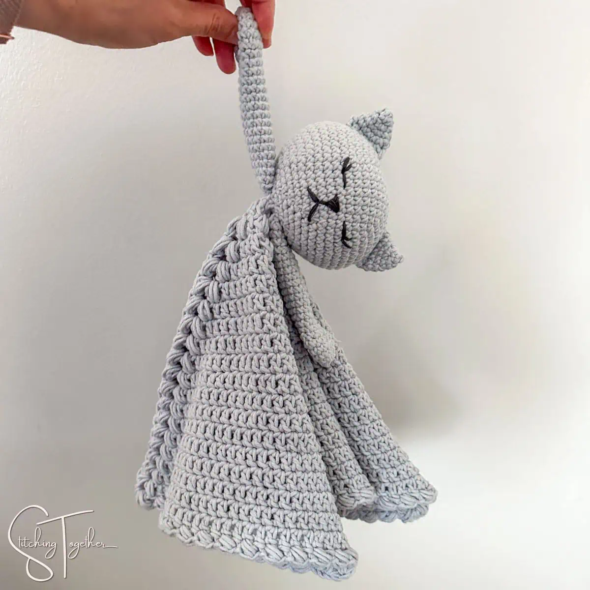 two crochet cat lovies laying next to each other