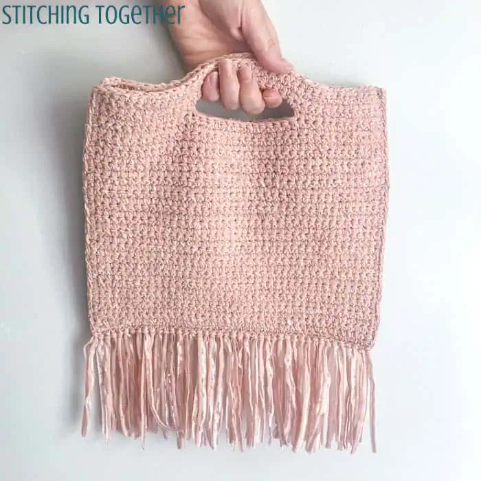 small pink crochet purse with fringe