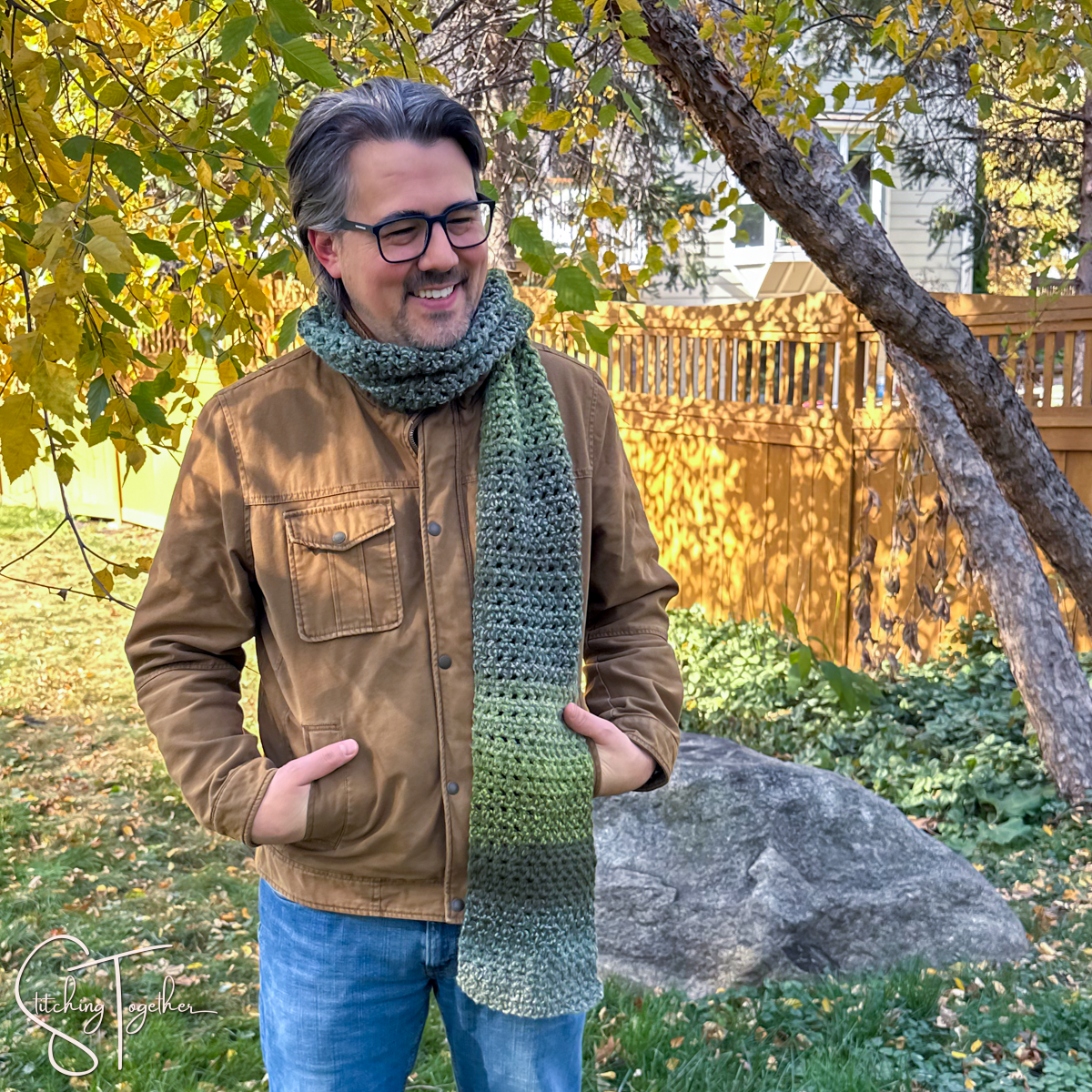 man wearing a chunky crochet scarf while standing outside