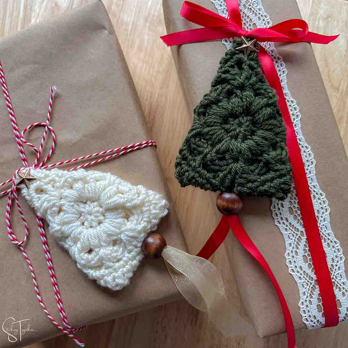 granny square Christmas trees laying flat on top of wrapped presents