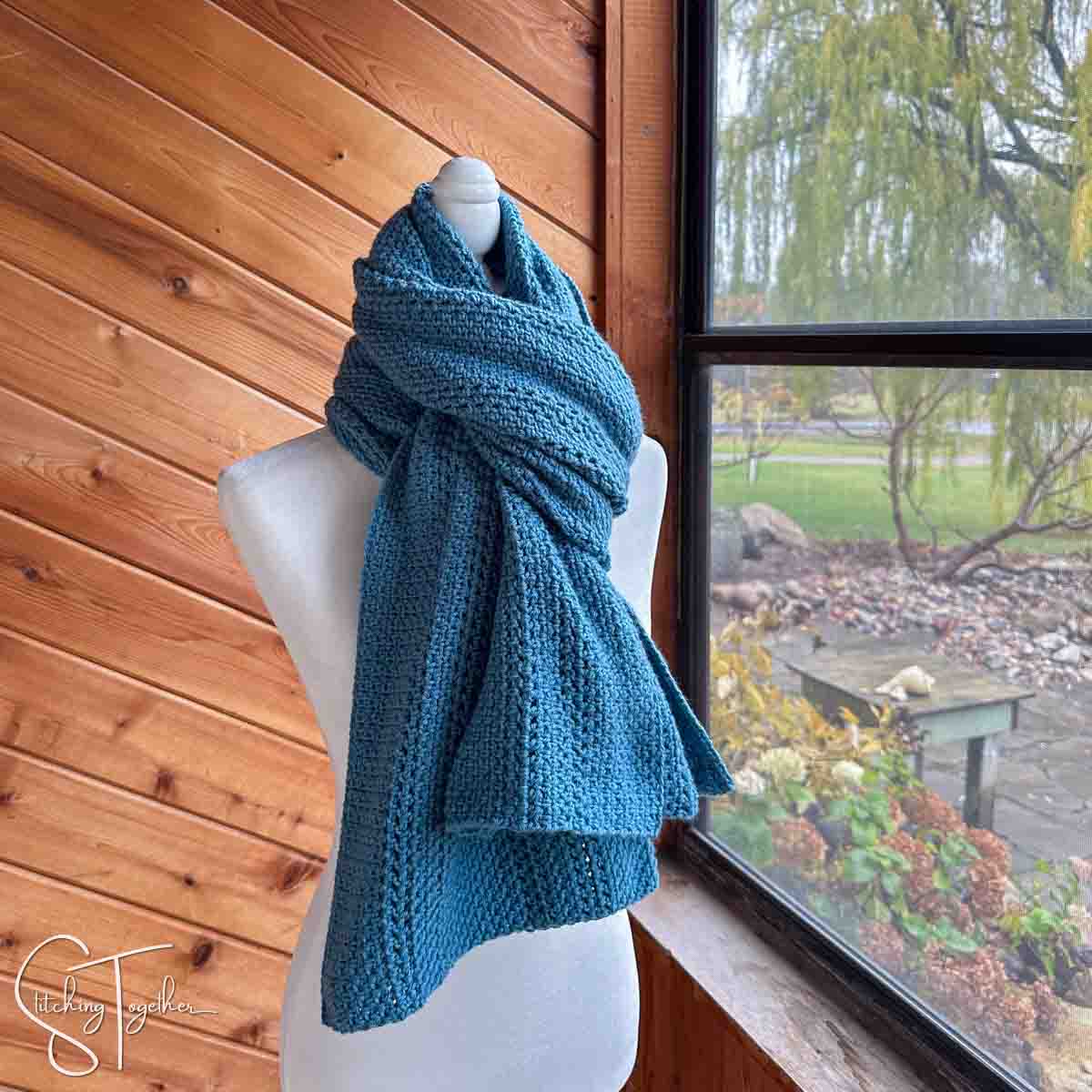 crochet shawl wrapped like a scarf on a headless mannequin
