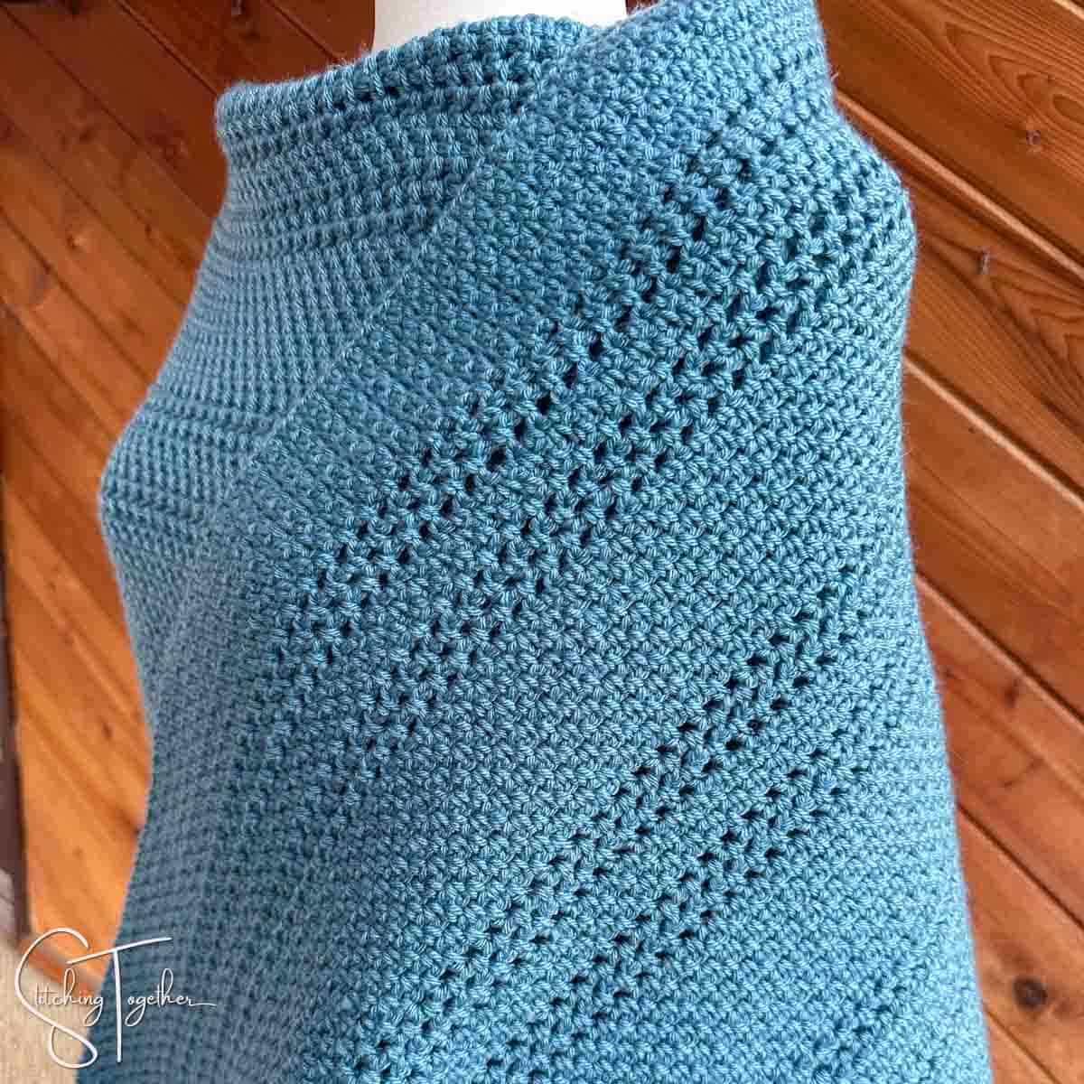 close up of the stitches of a blue crochet shawl