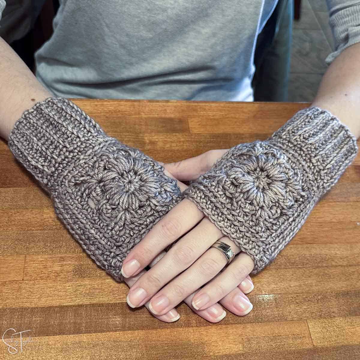 hands wearing crochet wrist warmers