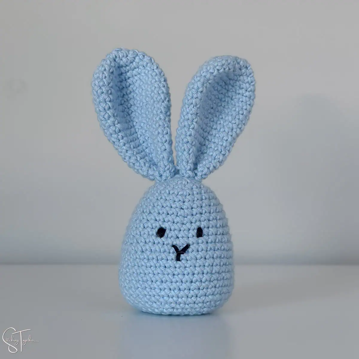 a blue crochet bunny shaped as an egg