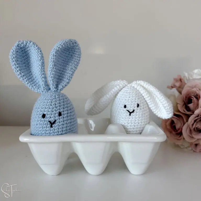 two crochet bunny eggs sitting in a little egg carton