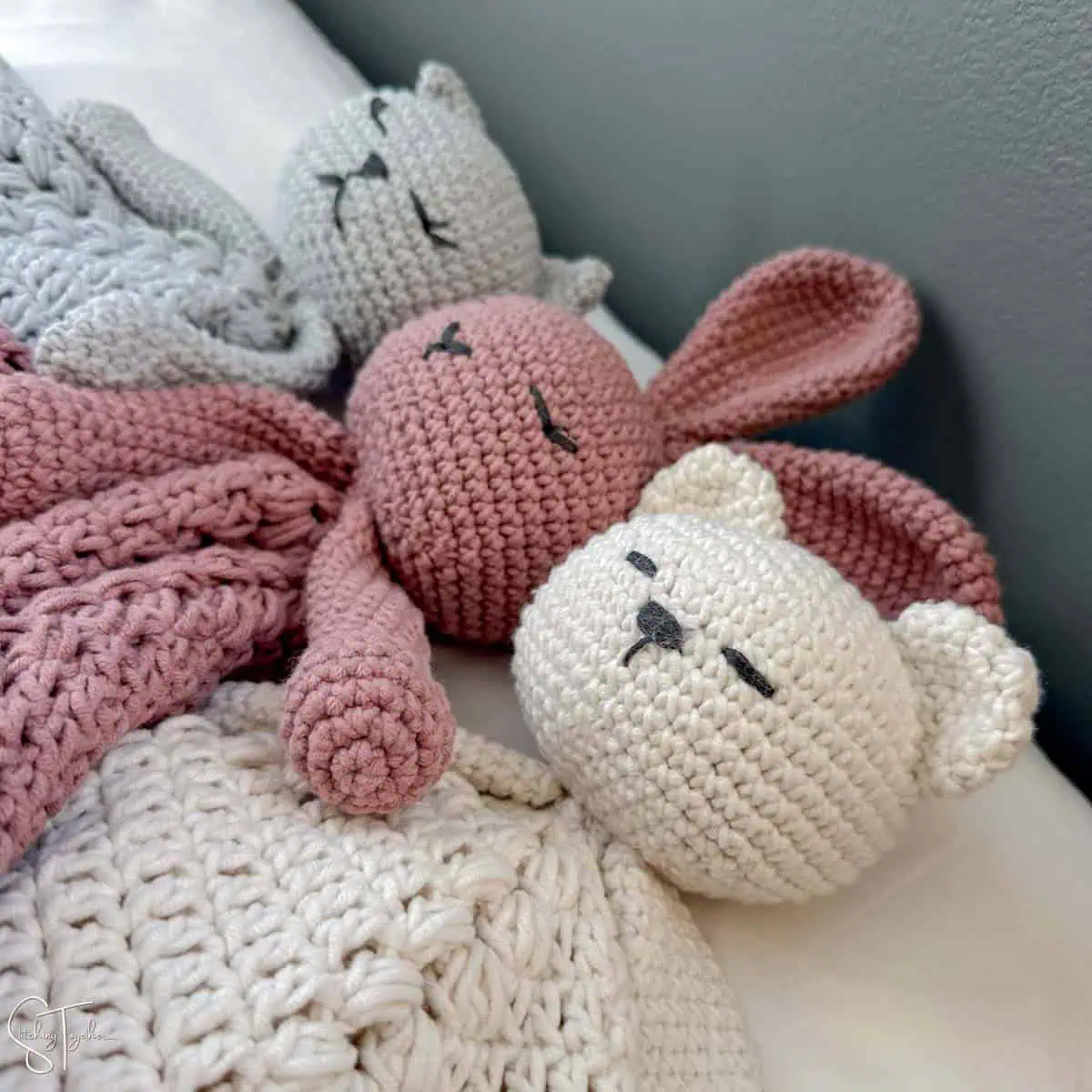 3 crochet amigurumi animals laying next to each other