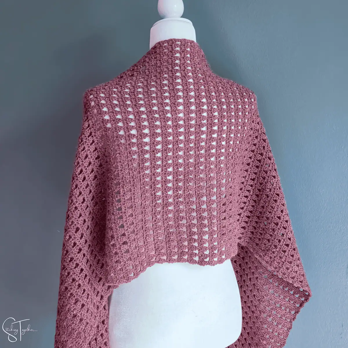 Back view of a rectangular crochet shawl draped on the shoulders of a mannequin
