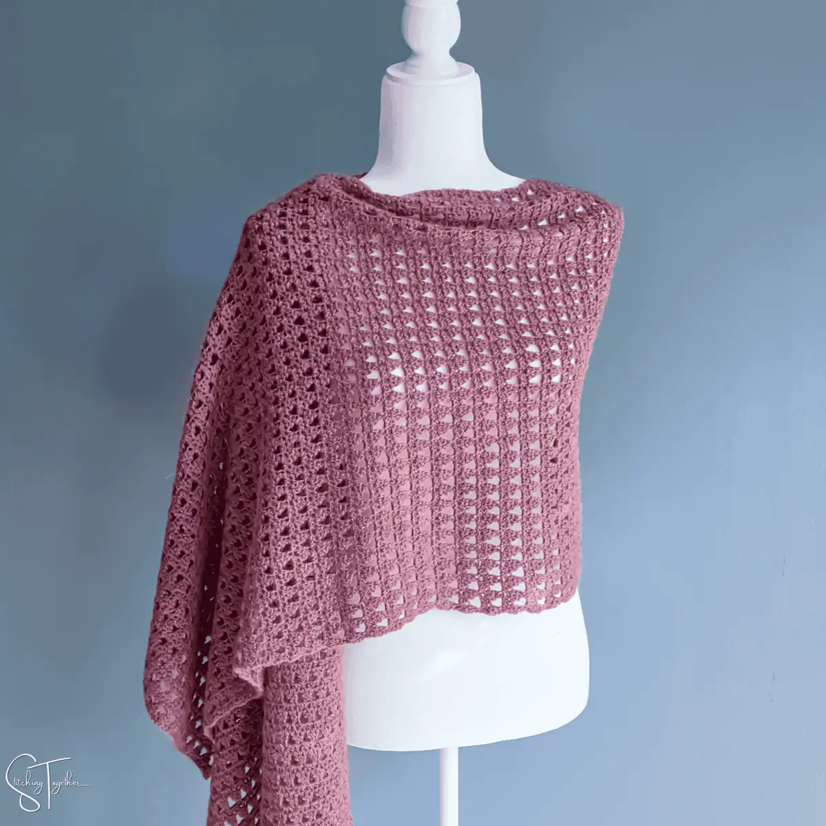 rectangular crochet wrap draped around the shoulders of a mannequin