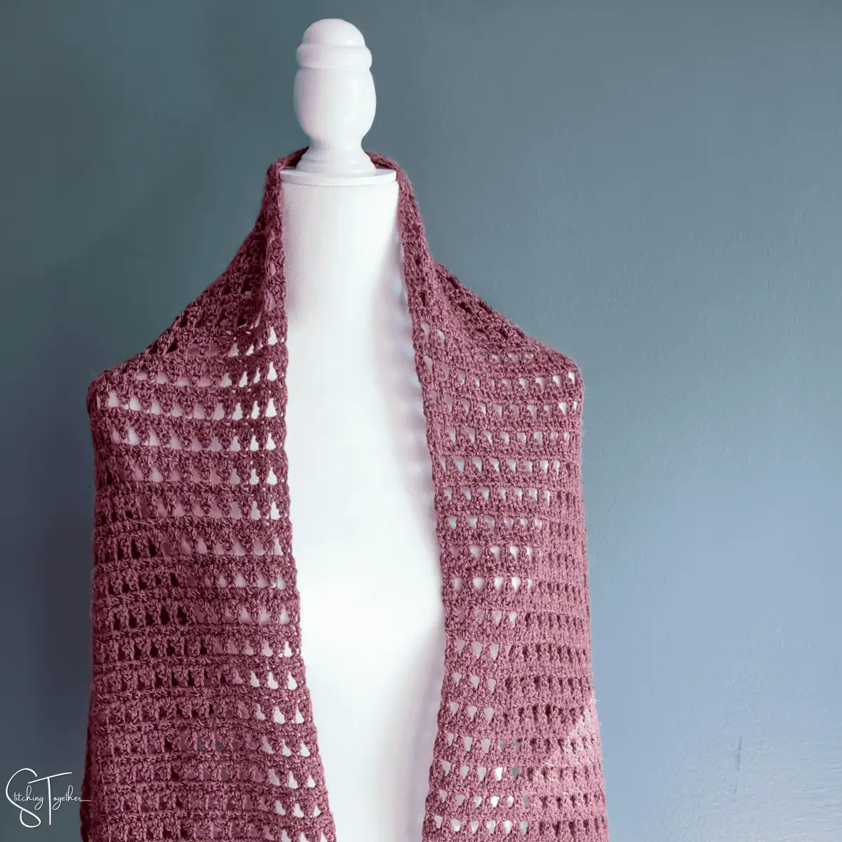 crochet shawl draped on the shoulders of a mannequin